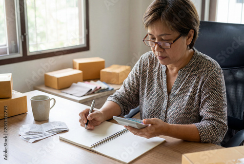 Small Business Owner Calculating Finances at Home Office