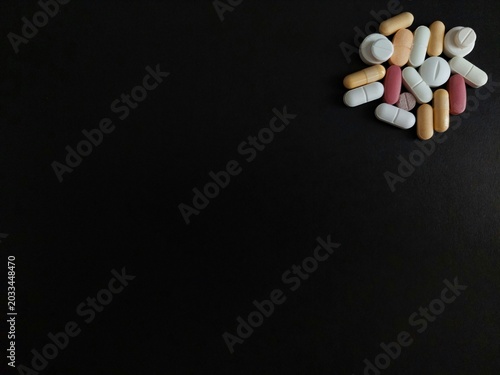 Tableau sur toile Assorted pills, tablets, capsules isolated on black background with copy space for drugs, medications, prescription medicines, medical treatments, vitamins, pharmaceuticals, and healthcare concepts