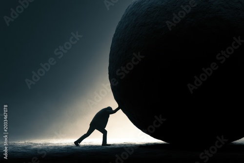 The Sisyphean Struggle: A lone figure in silhouette pushes against an immense, imposing stone sphere, symbolizing the monumental effort required to overcome overwhelming challenges.