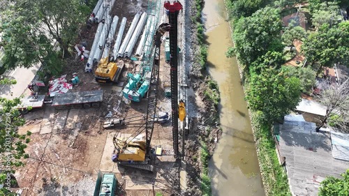 dredging mud on the riverbank in densely populated areas in the city center using heavy equipment such as excavators and dump trucks
