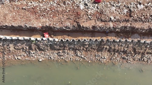 dredging mud on the riverbank in densely populated areas in the city center using heavy equipment such as excavators and dump trucks