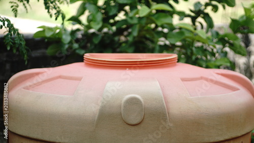 Close up of an orange plastic water tank cover in the backyard