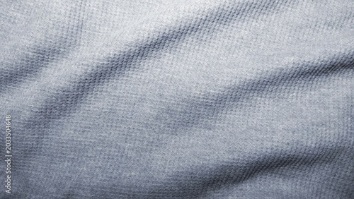 Light gray waffle knit fabric texture background with soft folds.