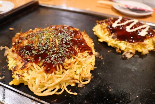 Bild auf Leinwand Freshly Cooked Okonomiyaki with Sauce and Mayonnaise on Hot Griddle