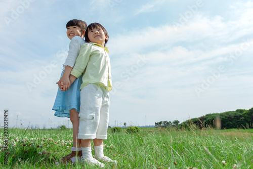 背中合わせで立つ女の子と男の子
