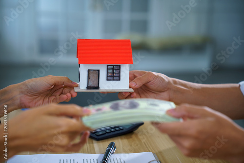 Real estate house model cash payment contract exchange office buyer seller show home purchase, mortgage loan approval, property sale closing on table with document, pen, calculator