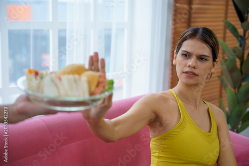 Billede på lærred Woman rejection sandwich junk food healthy hand diet control indoor sofa