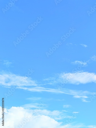 Minimalist calm blue sky background with soft white clouds texture copy space wallpaper concept