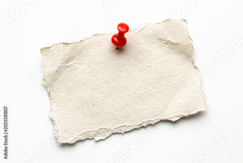 Beige paper scrap with red pin