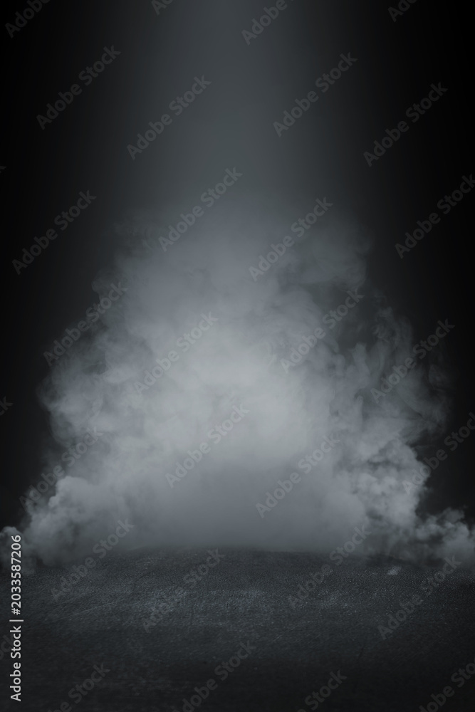 Fototapeta premium Dense white smoke billowing from a dark stage floor in dramatic lighting