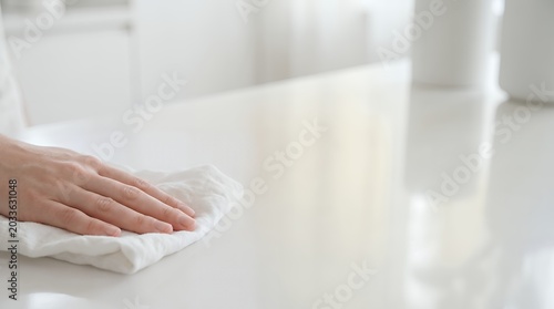 Close up of hand wiping a clean white surface with a cloth