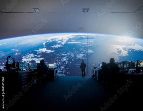 aerospace engineers monitoring orbital debris threats in a futuristic satellite tracking and communication control room.