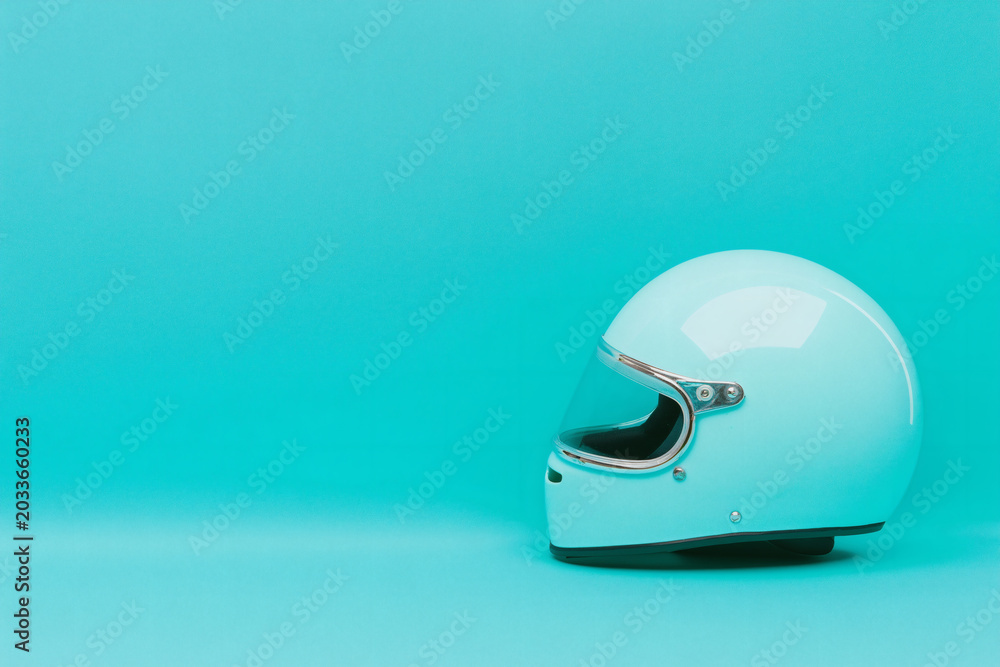 Fototapeta premium Retro full face motorcycling helmet isolated on cyan background with copy space