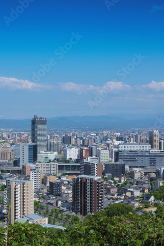 Panoramic view of the cityscape around Kumamoto Station from a hill in May, no people