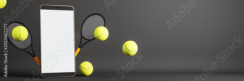 Smartphone with blank screen surrounded by tennis balls and rackets on dark b...