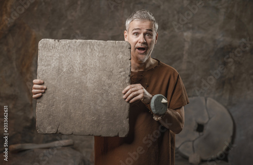 Canvastavla Surprised Caveman Holding Blank Stone Tablet with Copy Space
