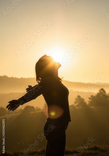 Silhouette of a Woman with Outstretched Arms at Sunrise, Concept of Freedom, Hope and Mindfulness in Nature