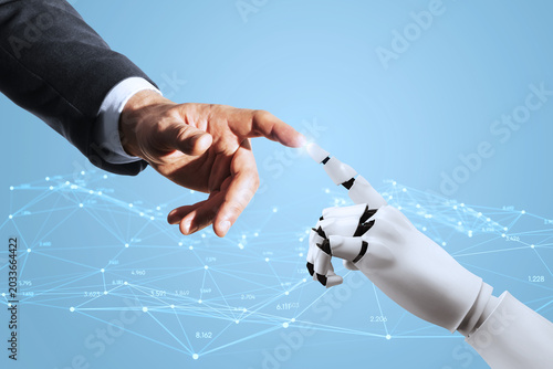 Human and robotic hand reaching to touch fingertips against a blue tech backg...