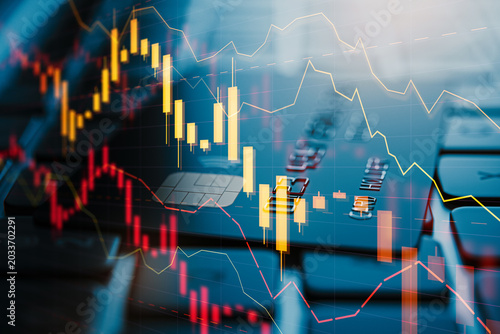 Financial market candlestick charts overlaid on blurred credit card surface c...