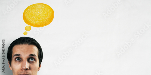 Man with yellow thought bubble above head on clean white background with ampl...