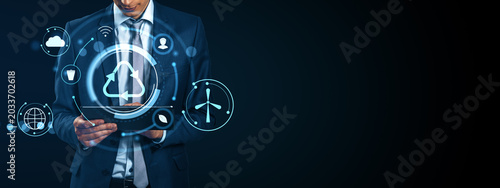 Businessman using digital tablet with glowing recycling, energy and eco techn...