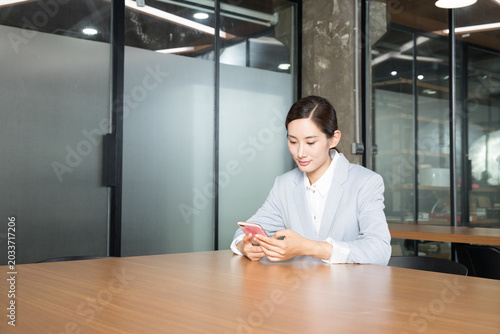 Schilderij op canvas Businesswoman Using Smartphone in Modern Office Meeting Room