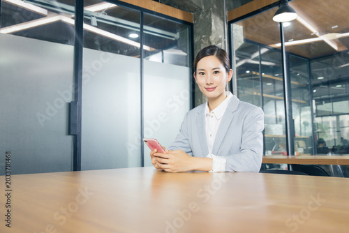 Foto Businesswoman using smartphone in modern office