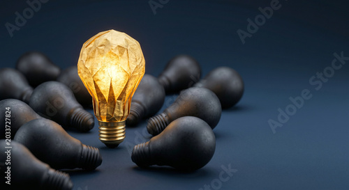 Glowing origami lightbulb standing out among unlit black lightbulbs, unique idea and leadership concept.