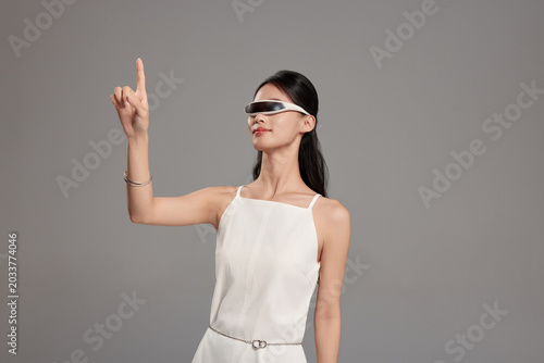 Woman using virtual reality headset and touching digital interface