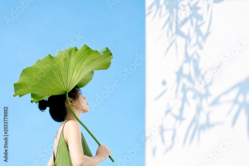 Woman with Lotus Leaf Umbrella in Summer