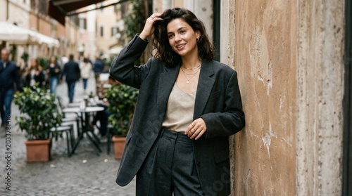 Woman in an oversized suit playing with her hair, modern fashion portrait with relaxed confidence, editorial styling and soft attitude appeal for apparel, beauty and culture themes, polished photoreal
