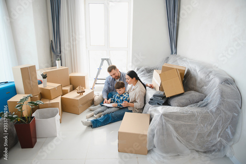 Obraz na plátně Family moving to new home unpacking living room