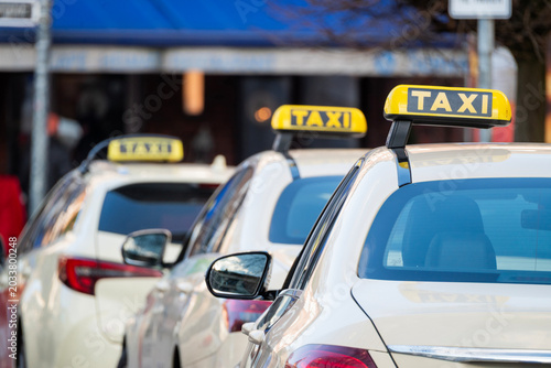 Canvastavla Row of taxis waiting at a taxi rank in a city street, rear view of cars with yellow signs
