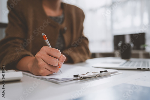 Business professional writing on document in office setting