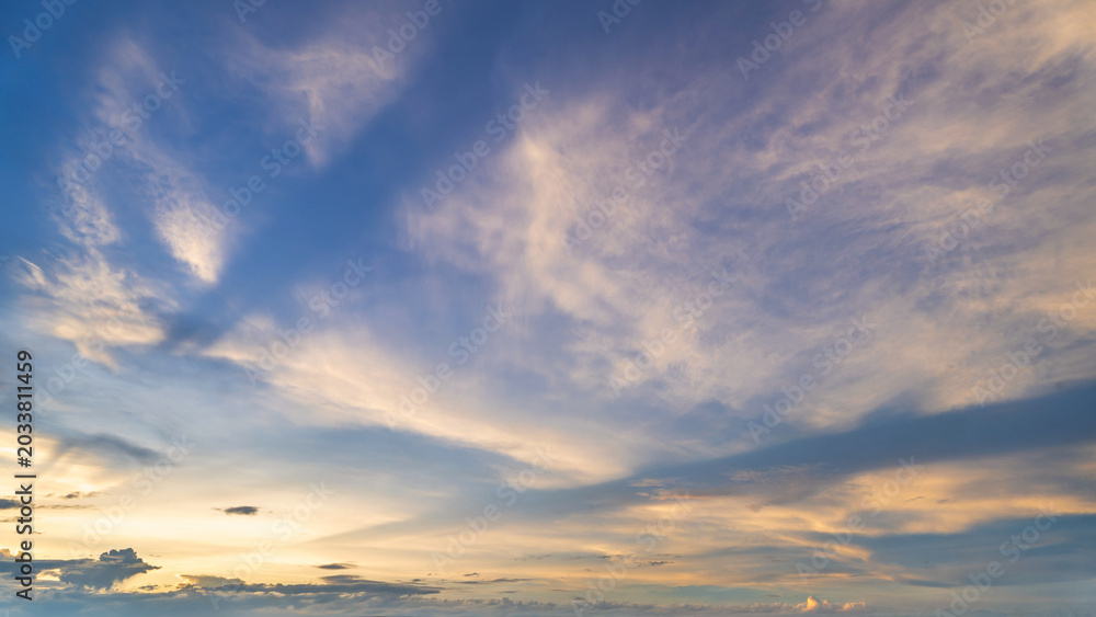 Fototapeta premium Twilight blue bright and orange yellow dramatic sunset sky in countryside or beach colorful cloudscape texture with white clouds air background.