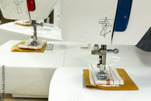 Photography White sewing machine with fabric samples under presser foot and needle for craft