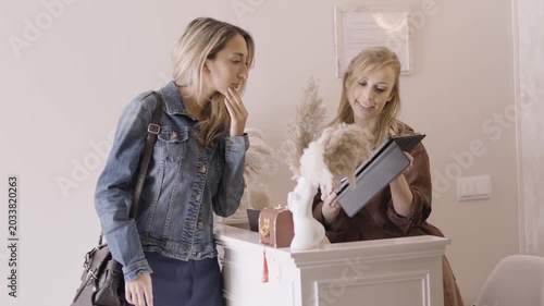 Professional receptionist assisting a client with a tablet