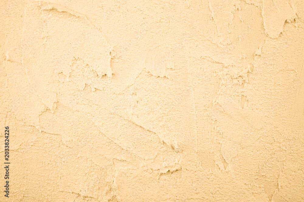 Fototapeta premium Pale yellow plaster wall texture with rough surface
