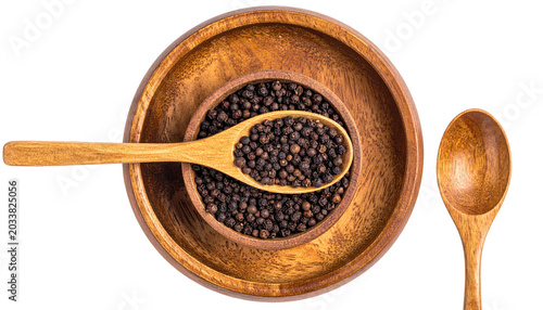 Wood bowls nestle, filled with black peppercorns, spoons nearby