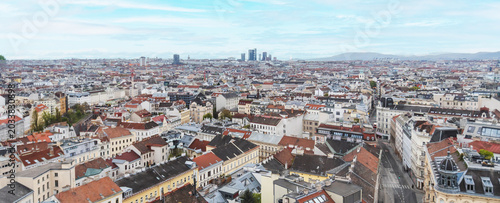 Vienna city skyline with historic rooftops and modern skyscrapers in the distance, high angle panoramic view.