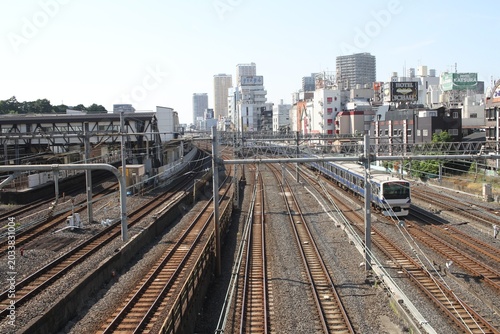 High angle view of multiple railway tracks and a running train in Tokyo.