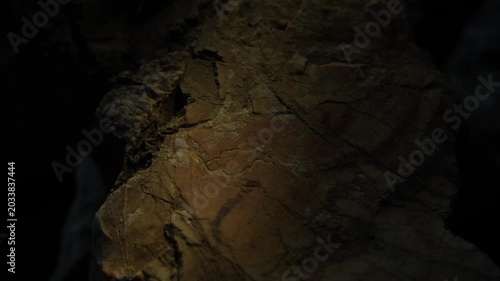 Warm light beam scanning rugged rock surface with cinematic texture