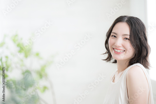Fotografie 自然光の部屋で微笑む女性の美容とナチュラルライフスタイルイメージ　カメラ目線のクローズアップ