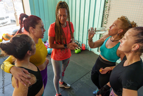 Photos Group of women taking a break after an intense workout, hydrating and discussing