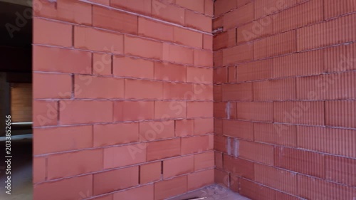 Unfinished room interior of house under construction. Brick red walls. New home.