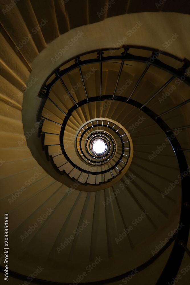 Fototapeta premium Elegant Spiral Staircase View from Below in a Historical Building with Fibonacci Pattern and Bright Light at the Top