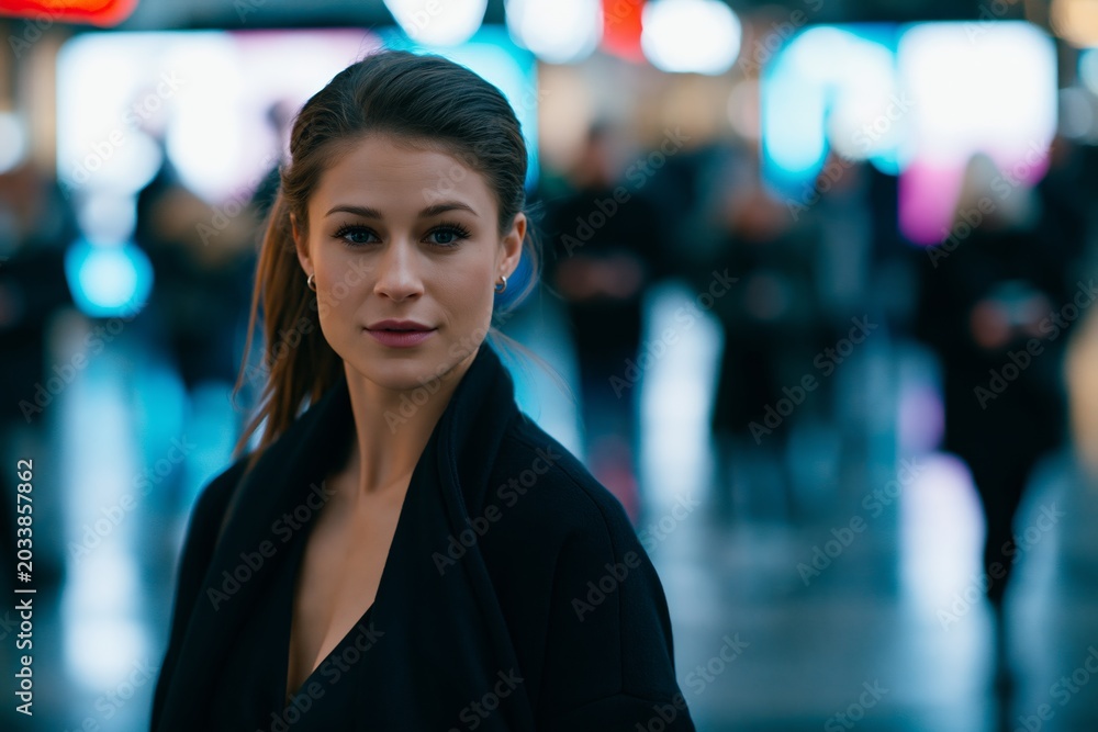 Obraz premium Young caucasian woman with confident expression in urban night scene