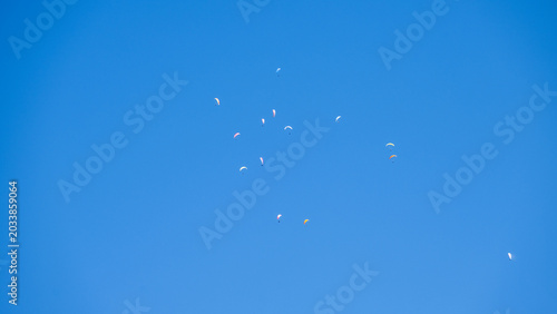 A blue sky full of paragliders