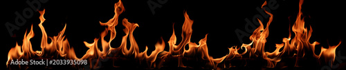 Fotografi Real fire flames isolated on black background with glowing orange heat, dramatic burning texture, abstract energy, danger, heatwave, ignition, wildfire, and hot flame banner design