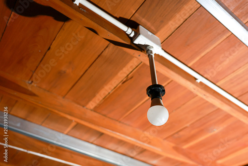 Принти на полотні Warm and inviting interior featuring bright light bulb hanging from rustic wood